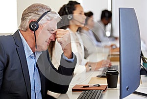 Stress, tired and mature man in call center with headache, pain or burnout for customer service mistake. Fatigue