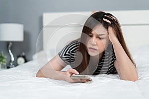 Stress woman using smartphone on bed