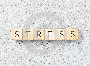 Stress word made with wooden blocks on grey background