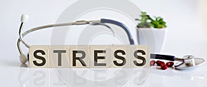 STRESS the word is written on the wooden cubes and sthetoscope and piils . Medical concept