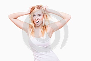 Stress. Young woman frustrated pulling her hair on white