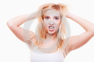 Stress. Young woman frustrated pulling her hair on white