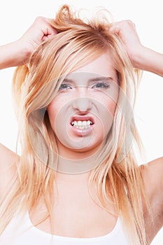 Stress. Young woman frustrated pulling her hair on white