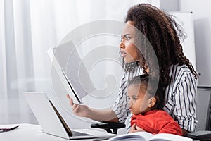 stressed african american mother holding folder