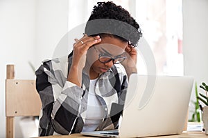 Stressed african woman concentrating doing difficult online computer work