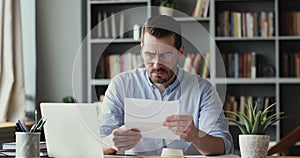 Stressed angry businessman reading banking credit loan refusal notification.