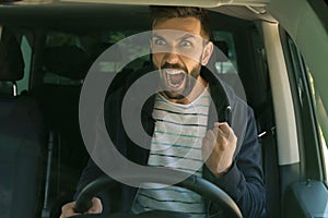 Stressed angry man in driver`s seat of modern car, view through windshield