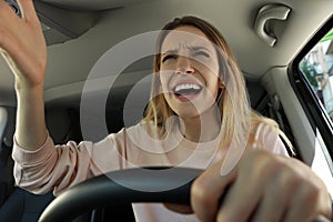 Stressed angry woman in driver`s seat of modern car