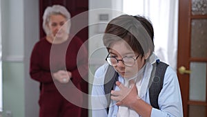 Stressed anxious schoolboy having panic attack as blurred mature woman shouting at background. Portrait of Caucasian son