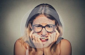 Stressed anxious young woman girl in glasses student biting fingernails