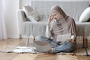 Stressed arabic woman having problems while working on laptop at home