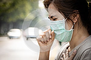 Stressed asian adult woman cough wearing hygienic mask,wet female forehead with sweating,worried about air pollution problems, photo