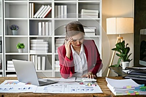 Stressed Asian businesswoman focuses on rechecking the business financial plan's report