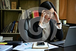 Stressed Asian businesswoman pensively thinking on a problems solutions