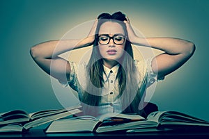 Stressed asian caucasian woman student learning in tons of books