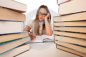 Stressed asian caucasian woman student learning in tons of books