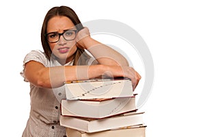 Stressed asian caucasian woman student learning in tons of books