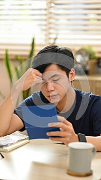 Stressed asian man having financial problem, anxiety about debt and managing expenses finances at home