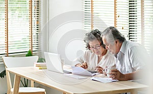 Stressed Asian Senior Couple using calculator and calculate family budget, Debts, monthly expenses in home during Financial