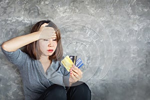 Stressed Asian woman hand holding credit cards having problem with overspending and debt