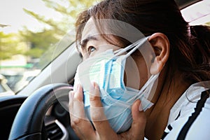 Stressed asian woman with protection masks of many layers,worried about inhaling toxic fumes,afraid of air pollution,PM 2.5,smog,