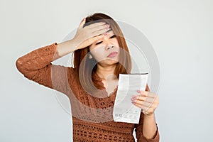 Stressed Asian woman shocked with number on electricity bill ,invoice having problem with payment