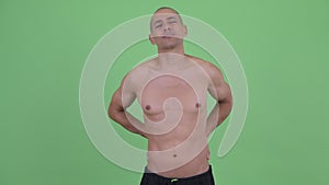 Stressed bald multi ethnic shirtless man having back pain