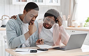 Stressed Black Couple Calculating Family Budget In Kitchen, Suffering Financial Crisis