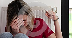 Stressed blonde woman handcuffed to radiator in captivity