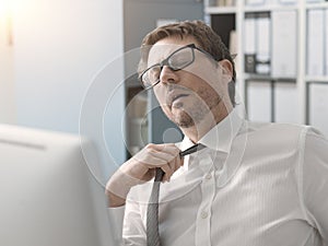 Stressed business executive loosening his tie