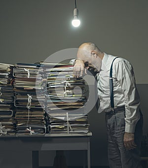 Stressed business executive overloaded with paperwork