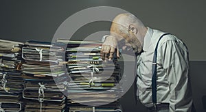 Stressed business executive overloaded with paperwork photo