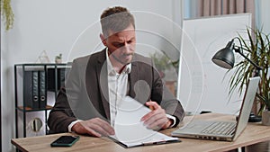 Stressed business man worried about financial paperwork problem money debt budget loss at office