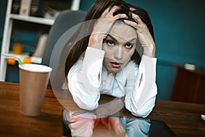 Stressed business woman feels emotional stress. Bored or crazy woman falling into stupor with coffee cup at workplace