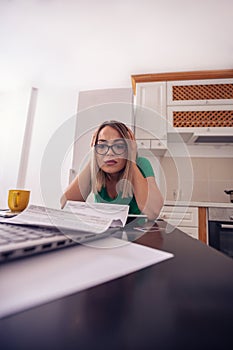 Stressed business woman at home working - planning budget and finances..
