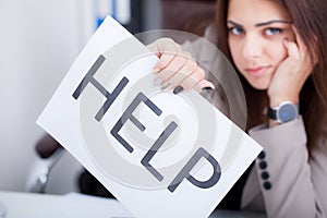 Stressed business woman imploring for help, holding a cardboard