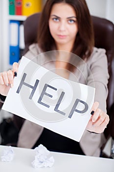 Stressed business woman imploring for help, holding a cardboard