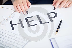 Stressed business woman imploring for help, holding a cardboard