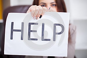 Stressed business woman imploring for help, holding a cardboard