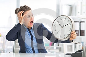 Stressed business woman looking on clock
