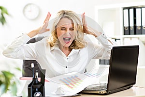 Stressed business woman screaming loudly working