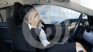 Stressed business woman sitting in car, suffering from headache, problems