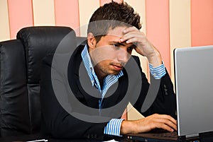 Stressed businessman browsing internet photo