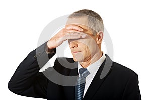 Stressed businessman covering his face