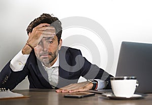 Stressed businessman feeling depressed and overwhelmed working at office computer desk tired and exhausted defeated by business f