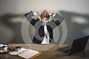 Stressed businessman feeling depressed and overwhelmed working at office computer desk tired and exhausted defeated by business f