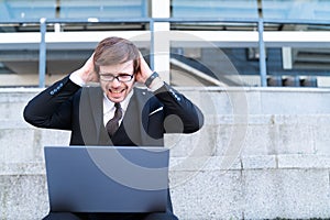 Stressed businessman with his head in hands frustration.