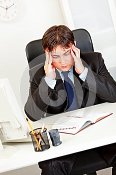 Stressed businessman holding his head and worrying