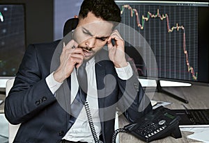 Stressed businessman on the phone, trading on the stock market during a financial crisis. Trader in a bear market with