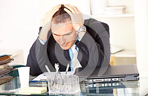 Stressed businessman sitting at desk